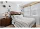 Well-lit bedroom with a striped comforter and large mirror at 766 N 153Rd Ave, Goodyear, AZ 85338