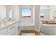 Relaxing bathroom with soaking tub, double vanity, and bedroom view at 20236 W Highland Ave, Litchfield Park, AZ 85340