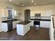 Kitchen with an island, stainless steel appliances, and dark countertops at 22130 N Van Loo Dr, Maricopa, AZ 85138