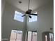 High-ceiling living room with a ceiling fan and large windows at 22130 N Van Loo Dr, Maricopa, AZ 85138