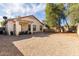 Large gravel backyard with covered patio and mature trees at 43842 W Elizabeth Ave, Maricopa, AZ 85138