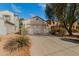 Exterior view showcasing a two-car garage and driveway at 43842 W Elizabeth Ave, Maricopa, AZ 85138