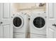 Bright laundry room with washer and dryer, and overhead shelving at 43842 W Elizabeth Ave, Maricopa, AZ 85138