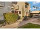 Side view of a light beige stucco building with a red door and walkway at 4610 N 68Th St # 417, Scottsdale, AZ 85251