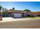 House exterior with a two-car garage and well-maintained lawn at 10225 W Denton Ln, Glendale, AZ 85307