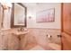 Elegant bathroom with pedestal sink and tiled walls at 10575 E Rising Sun Dr, Scottsdale, AZ 85262