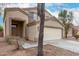 Two-story home with attached two-car garage, desert landscaping, and a tree by the walkway at 21869 W Mohave St, Buckeye, AZ 85326