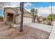 Two-story home with attached two-car garage, desert landscaping, and a tree at 21869 W Mohave St, Buckeye, AZ 85326