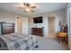Bright bedroom featuring a large TV, dresser, and ensuite bathroom access at 22918 E Marsh Rd, Queen Creek, AZ 85142