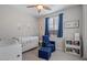 Bedroom with crib, armchair, and plenty of bookshelves at 22918 E Marsh Rd, Queen Creek, AZ 85142