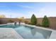 Relaxing pool with a stone waterfall feature and spacious patio at 22918 E Marsh Rd, Queen Creek, AZ 85142