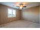 Bedroom with ceiling fan and large window with shutters at 42575 W Abbey Rd, Maricopa, AZ 85138