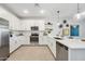 Modern white kitchen with stainless steel appliances and an island at 7958 W Sands Rd, Glendale, AZ 85303