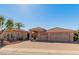 Exterior view of a two-story home with a three-car garage, paver driveway, and desert landscaping at 10325 W Bayside Rd, Sun City, AZ 85351