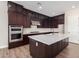 Modern kitchen with dark cabinetry, quartz countertops and stainless steel appliances at 19743 W Exeter Blvd, Buckeye, AZ 85340
