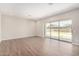 Bright living room featuring wood-look floors and sliding glass doors leading to the backyard at 19743 W Exeter Blvd, Buckeye, AZ 85340