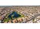 Aerial view of community with lake, mature trees, and numerous homes at 26606 S Foxglenn Dr, Sun Lakes, AZ 85248