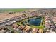 Aerial view showcasing a neighborhood with a central lake and lush landscaping at 26606 S Foxglenn Dr, Sun Lakes, AZ 85248