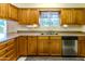 Kitchen with wood cabinets, double sink and dishwasher at 10103 W Forrester Dr, Sun City, AZ 85351