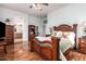 Main bedroom with a large wood bed frame and ensuite bathroom access at 17218 N 54Th Ln, Glendale, AZ 85308