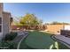 Landscaped backyard featuring a putting green and hot tub at 1864 W Buckhorn Trl, Phoenix, AZ 85085