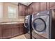 Laundry room with washer, dryer, and dark wood cabinets at 1864 W Buckhorn Trl, Phoenix, AZ 85085