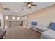 Spacious loft area with plush seating and a ceiling fan at 1864 W Buckhorn Trl, Phoenix, AZ 85085
