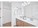 Bathroom with dual vanity sinks, wooden cabinetry, and a tiled floor at 20385 W Terrace Ln, Buckeye, AZ 85396