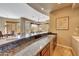 Wet bar with granite countertop and mini-refrigerator at 24686 N 120Th Pl, Scottsdale, AZ 85255