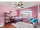 Charming bedroom with pink walls and a comfy sitting area at 31511 N Shale Dr, San Tan Valley, AZ 85143