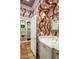 Elegant bathroom with marble vanity, patterned wallpaper, and tiled shower at 5317 N 46Th St, Phoenix, AZ 85018