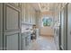 Bright laundry room with custom cabinetry, work space, and window at 6322 E Turquoise Ave, Paradise Valley, AZ 85253