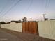 Wooden gate and tall gray fence surrounding the property at 8249 W Earll Dr, Phoenix, AZ 85033