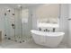 Modern bathroom with a large walk-in shower and free-standing tub at 943 N 97Th Way, Mesa, AZ 85207