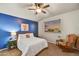 Bright bedroom with a queen bed, ceiling fan, and relaxing sitting area at 13281 N 71St Dr, Peoria, AZ 85381