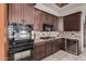 Well-equipped kitchen featuring dark wood cabinets, stainless steel appliances, and a wine cooler at 2632 E Camina Plata --, Gilbert, AZ 85298