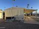 Side view of a mobile home with covered patio and AC unit at 4065 E University Dr # 276, Mesa, AZ 85205