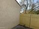 Tan stucco wall with a wooden fence and a tree at 4766 W Rose Ln, Glendale, AZ 85301