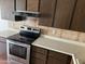 Electric stove and dark wood cabinets in kitchen at 4766 W Rose Ln, Glendale, AZ 85301
