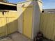 Yellow storage shed with a yellow door and wooden fence at 4766 W Rose Ln, Glendale, AZ 85301