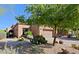 Front view of a tan stucco house with desert landscaping at 6934 E Bramble Berry Ln, Scottsdale, AZ 85266