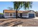 Single-story home with gray exterior, dark garage door, and a tree in front at 13525 S Burma Rd, Arizona City, AZ 85123