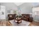 Cozy living room with comfortable leather furniture, high ceilings, and wood-look flooring at 13852 N 91St Ln, Peoria, AZ 85381