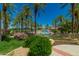 Resort-style pool with palm trees and a playground in background at 15137 W Cactus Ridge Way, Surprise, AZ 85374