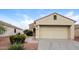 Tan house with stone accents, two-car garage, and landscaped yard at 22409 N Los Gatos Dr, Sun City West, AZ 85375
