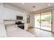 Kitchen with white cabinets, stainless steel appliances, and access to backyard at 22409 N Los Gatos Dr, Sun City West, AZ 85375