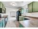 Modern kitchen with green cabinets, stainless steel appliances, and tile floors at 25370 W Jackson Ave, Buckeye, AZ 85326