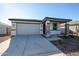 New single-story home with gray exterior, stone accents, and a two-car garage at 35605 W Mallorca Ave, Maricopa, AZ 85138