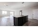 Modern kitchen with a large island, dark cabinets and tile flooring at 35625 W Mallorca Ave, Maricopa, AZ 85138