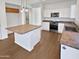 Modern kitchen with white cabinets, an island, and wood-look floors at 40728 N Hudson Trl, Anthem, AZ 85086